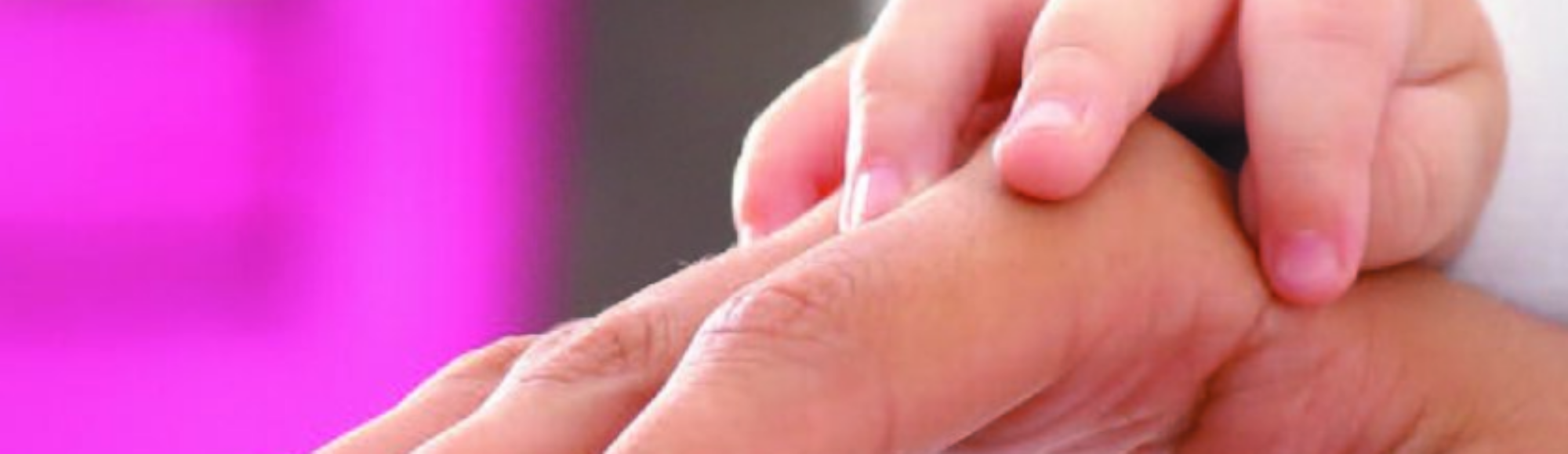 Main de bébé sur main d'adulte posée sur un pad